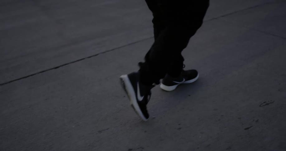 A man walks on a sidewalk