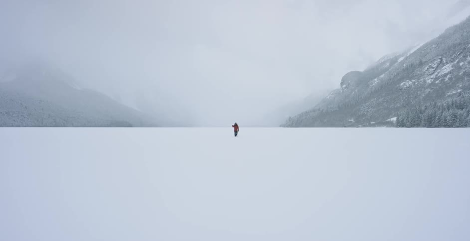 Someone is walking across a snow covered valley