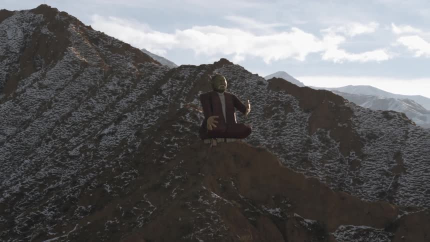 A giant statue perches on a mountain top under cloudy skies