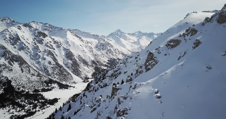 Large snow covered mountains with a blue sky in the background