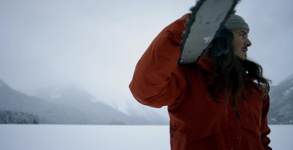 A man turns around with a chainsaw on his shoulder