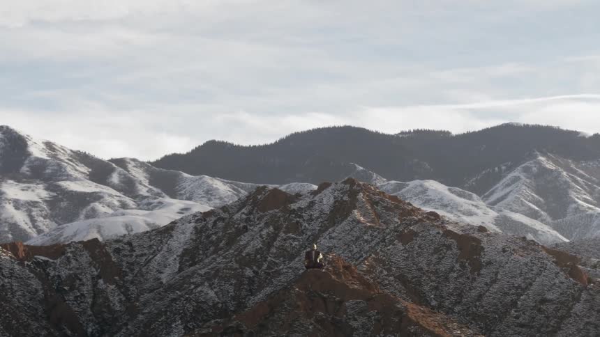 A statue is sitting on top of a frozen mountain