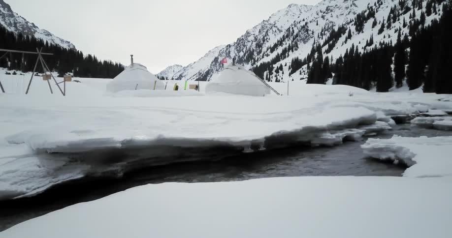 A river flows through a snowy landscape in the mountains