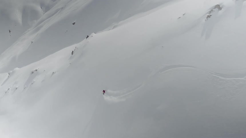 A skier is making their way down at high speed in the backcountry