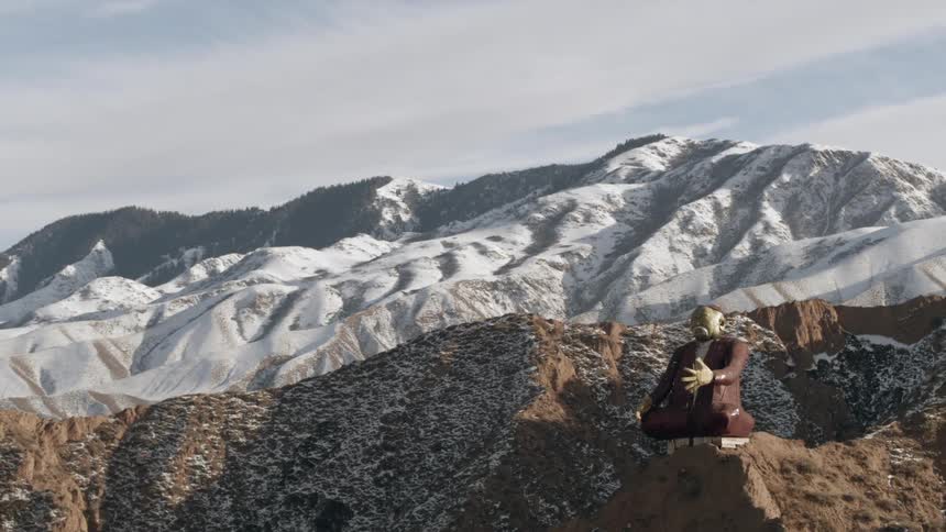 A statue sits on a mountain peak
