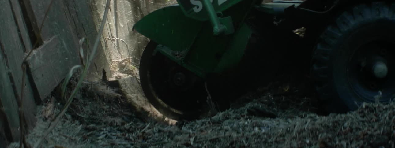 A stump is ground by a large saw