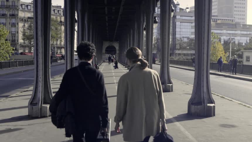 Two people are walking underneath a covered walkway