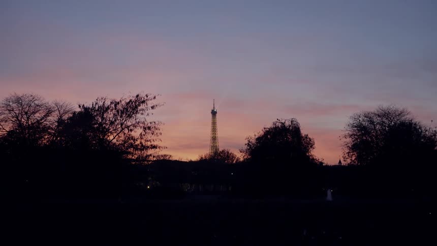 A tower stands in the distance at sunset
