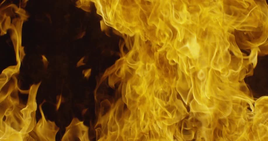 A fire burns outside at night