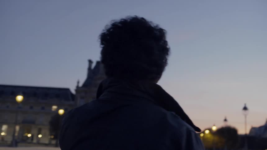Someone is taking photos of a building at dusk