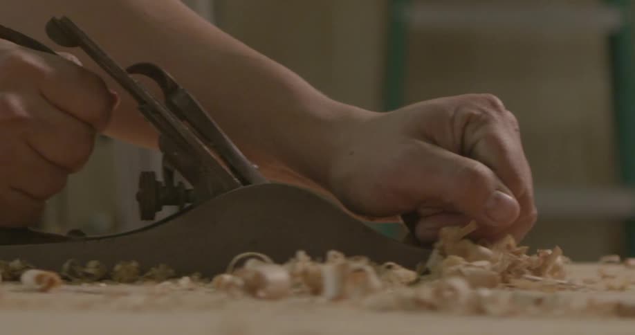 A man is sawing boards