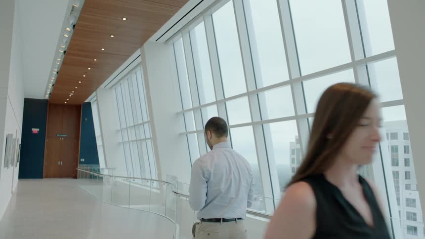 A woman walks past a man and nods to him