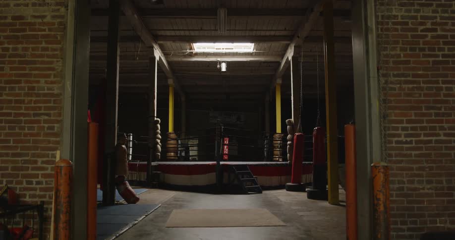 A brick building with an open door revealing a boxing ring inside