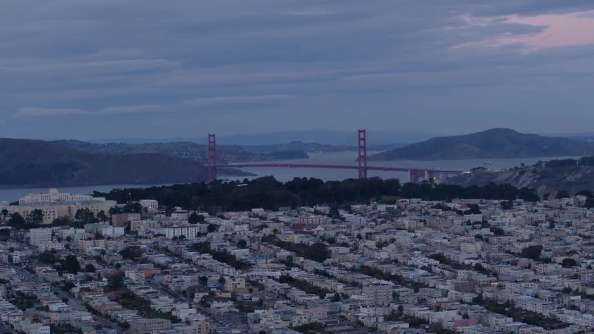 Clouds are hanging in the sky over the golden gate bridge at dawn
