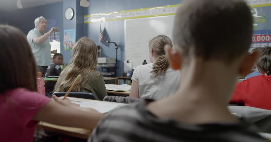 School children are taught by a teacher in a classroom