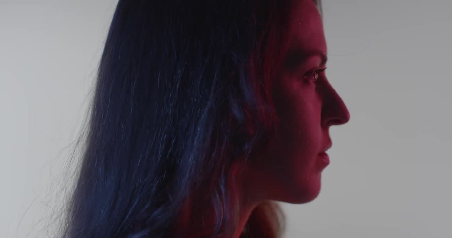 A woman with long hair stands in profile