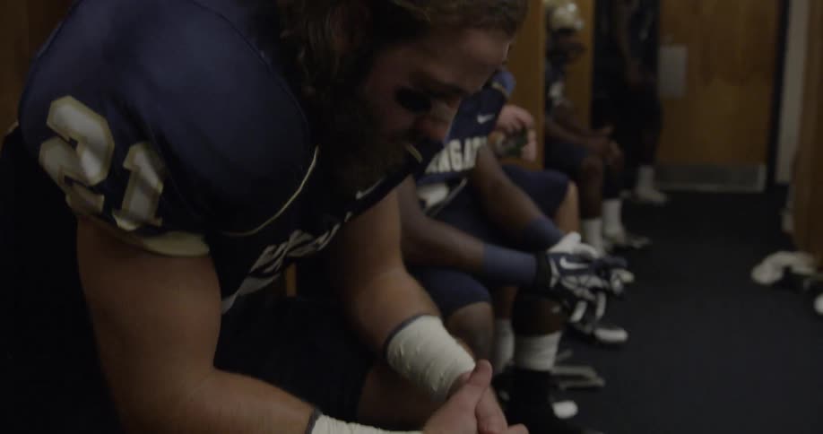 The football players are sitting in the locker room together