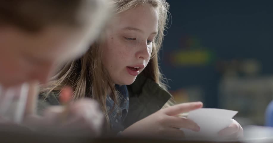 A young girl reads from index cards