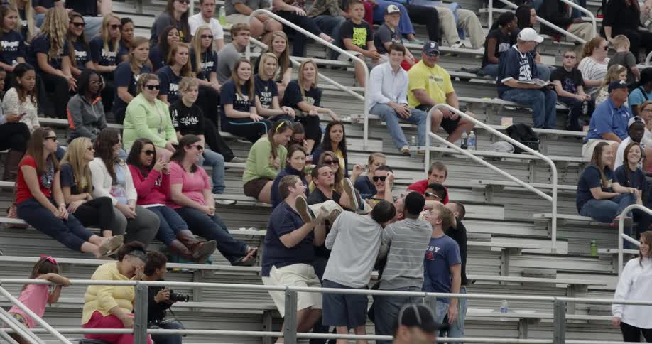 A group of men throw an audience member into the air