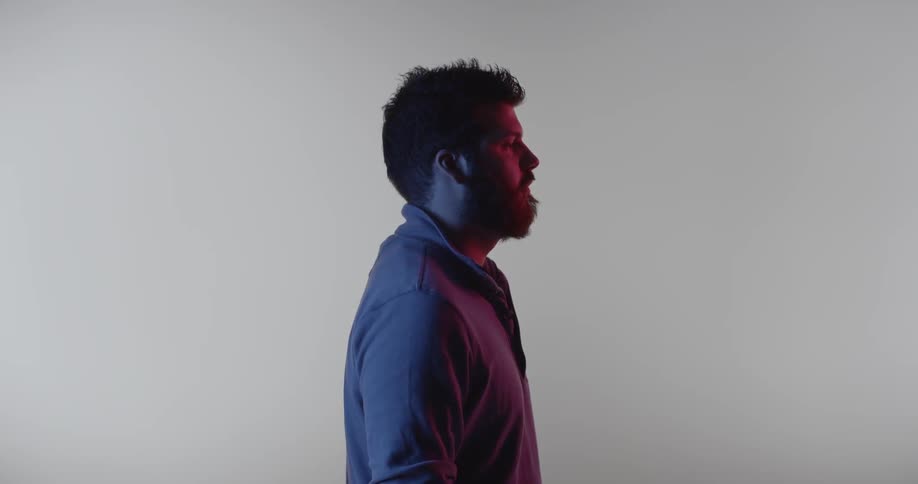 A man stands in front of a white backdrop