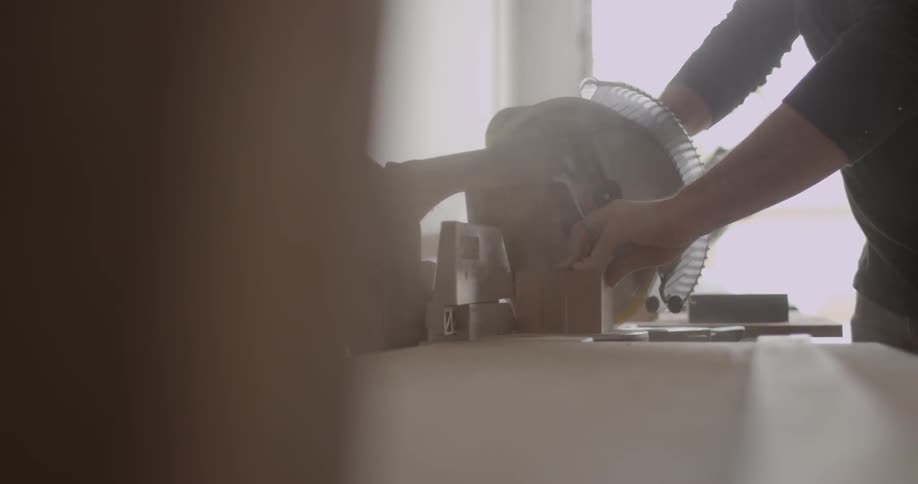 A person is cutting wood with a circular saw
