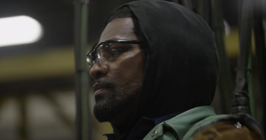 A man works in a factory while wearing safety glasses