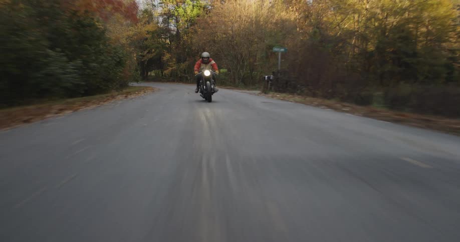 A motorcycle races on the small road