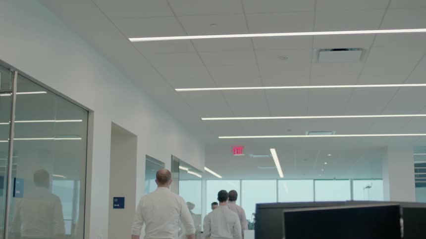 People are walking in an office during the day