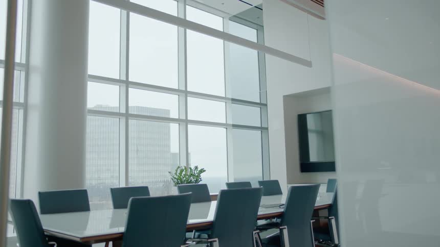 A conference table sits empty in a boardroom during the day