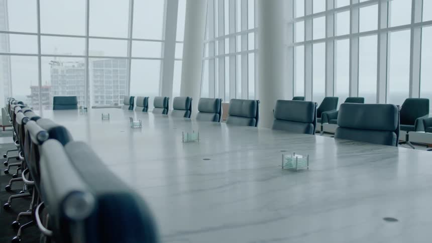 A large table with a lot of chairs is empty