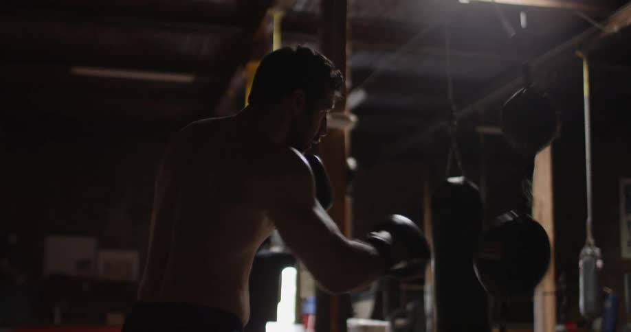 A man wearing gloves trains by punching the double end bags