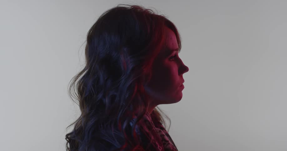 A girl blinks slowly staring in the dark