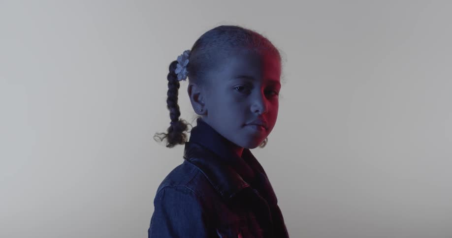 Girl in braided pigtails looking seriously into the camera