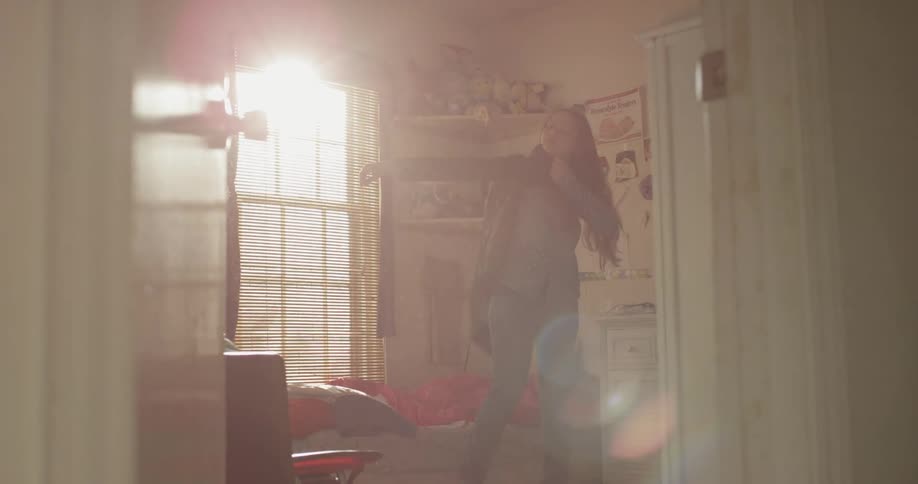 A girl gets up in the bedroom and puts on her jacket