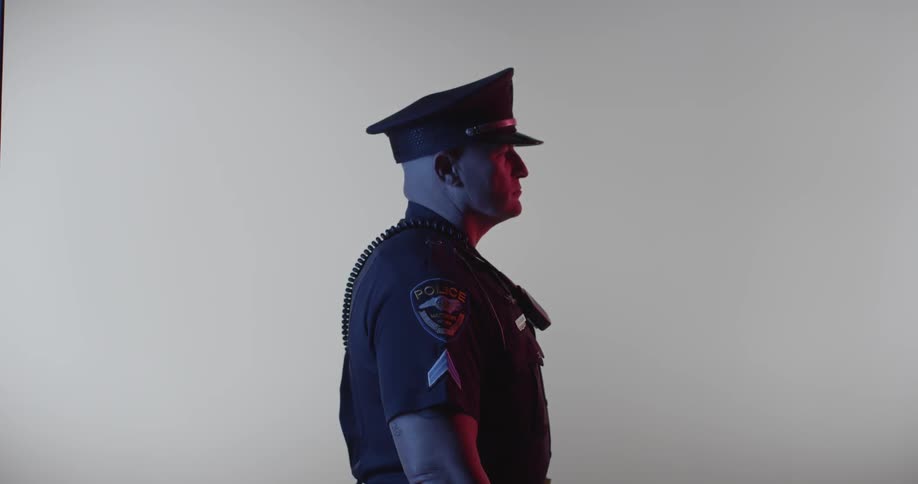 A police officer is standing to the side in the dark