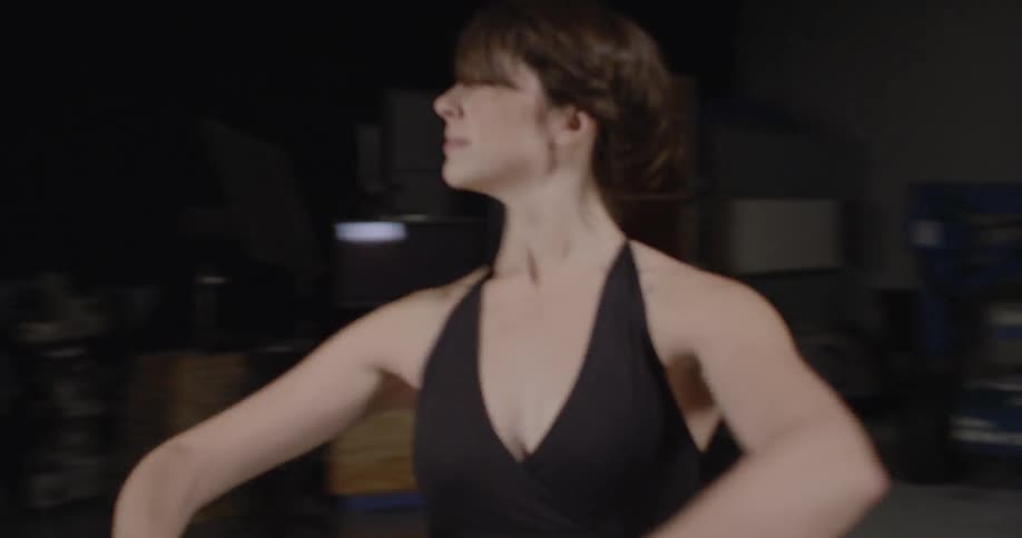 A ballerina does pirouettes in front of a floodlight