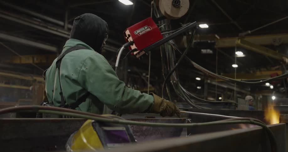 A man welds large steel beams