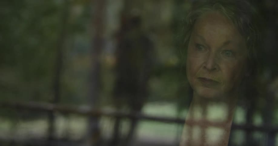 A woman is watching people threw a window