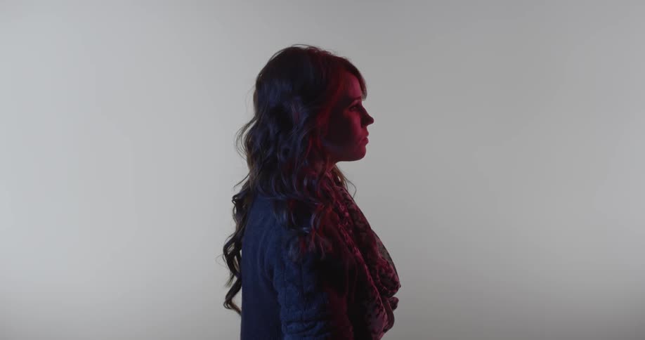 Woman with wavy hair looking solemnly forward