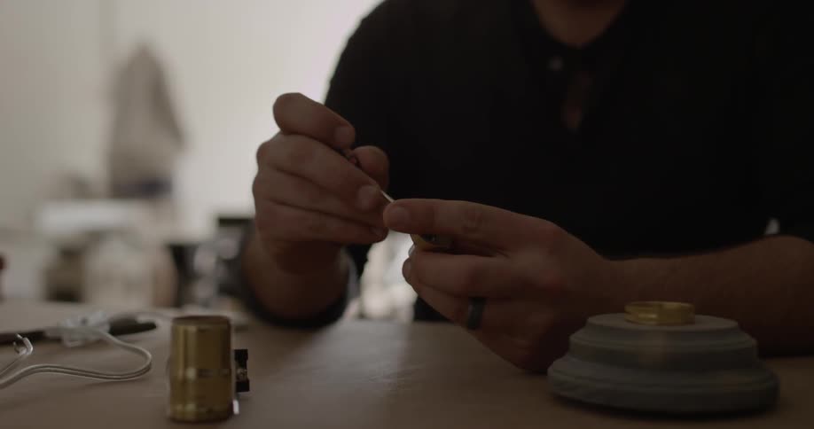 A man uses a small screwdriver to fix a valve