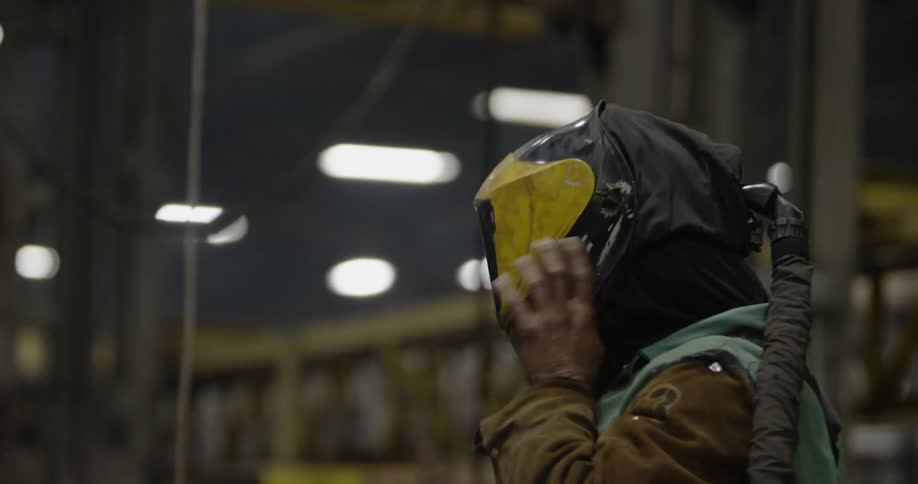 A man puts on a welding helmet