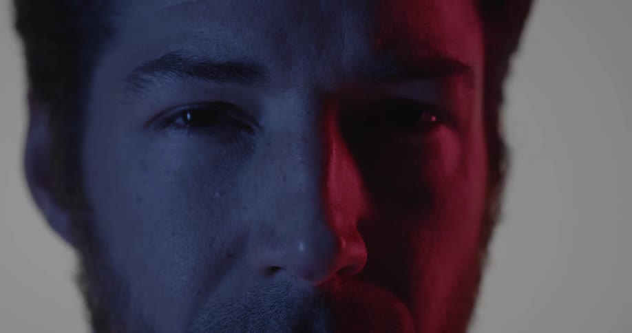 A man stares intently in a dim room