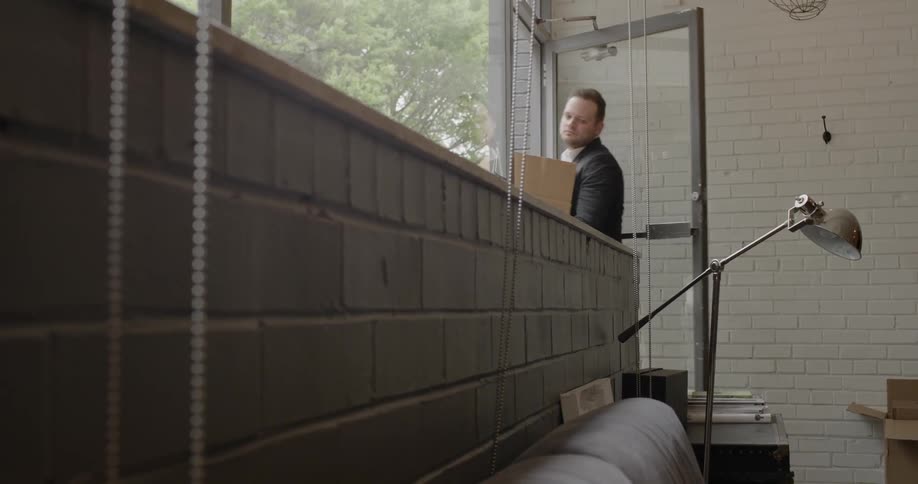 A man enters an office with a cardboard box