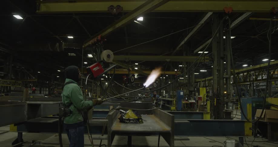 A person lights off a flamethrower in the warehouse