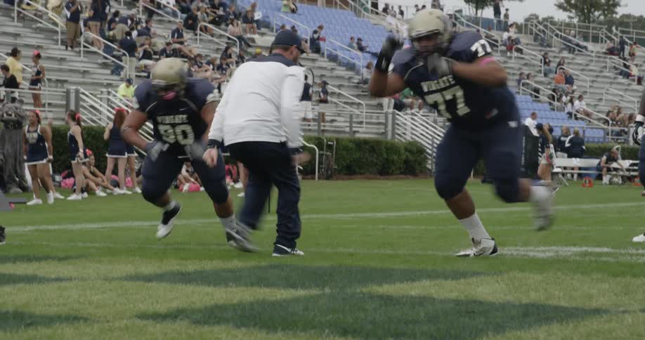 The football players run down the field together