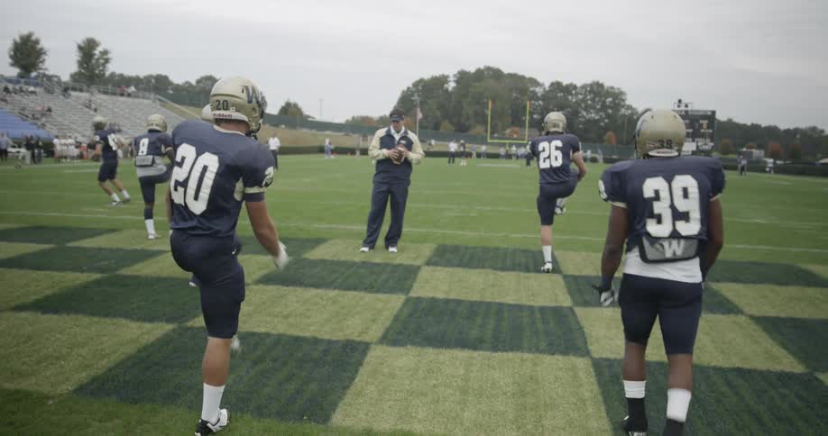 Football players stretch on an outdoor field