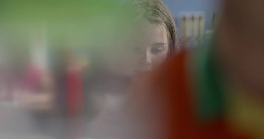 A young girl reads note cards in school