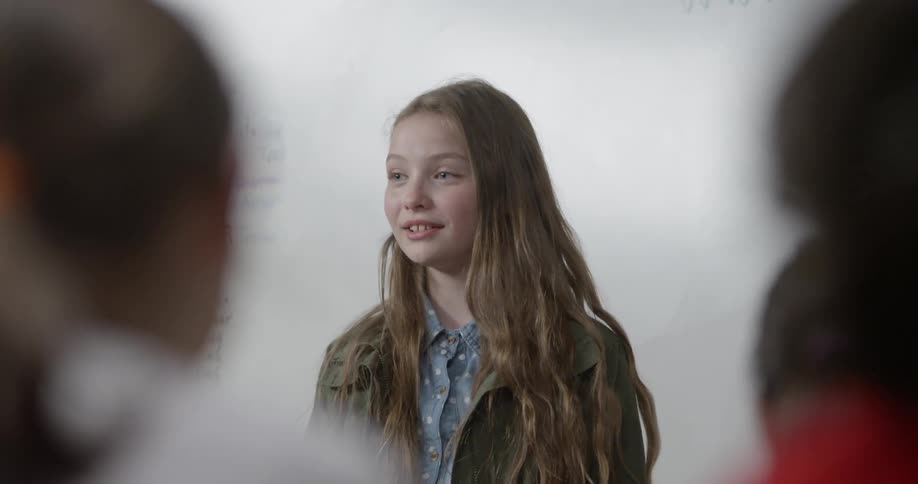 A young girl speaks to the class