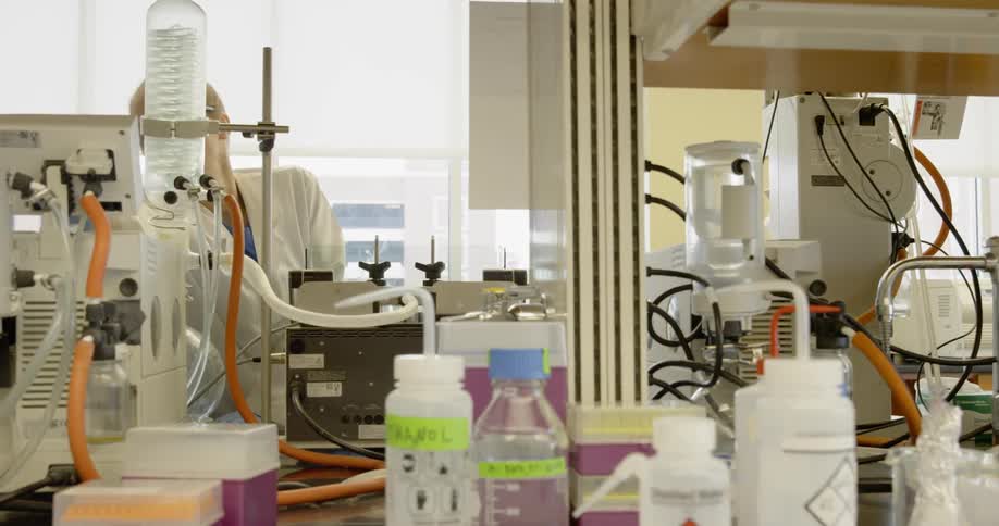 A woman works on scientific equipment in a laboratory