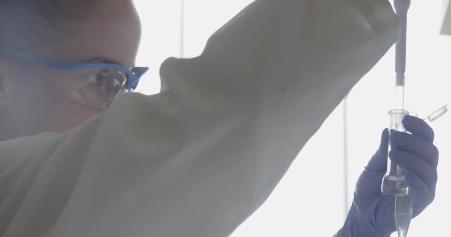A scientist pipettes liquid in a laboratory